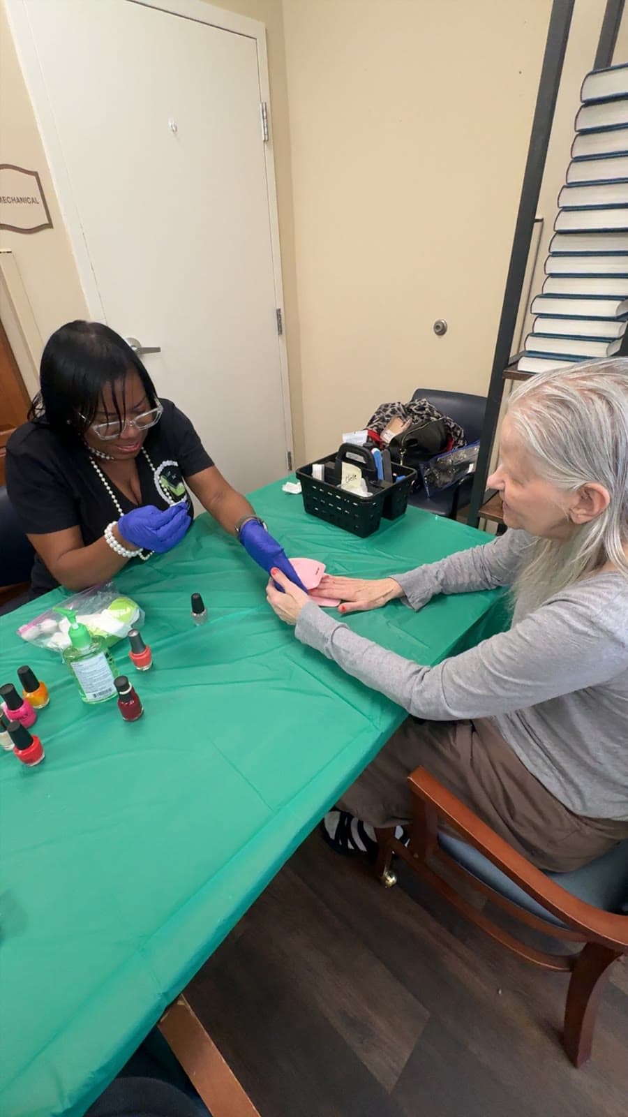 One-on-one nail polishing moment between a volunteer and a senior