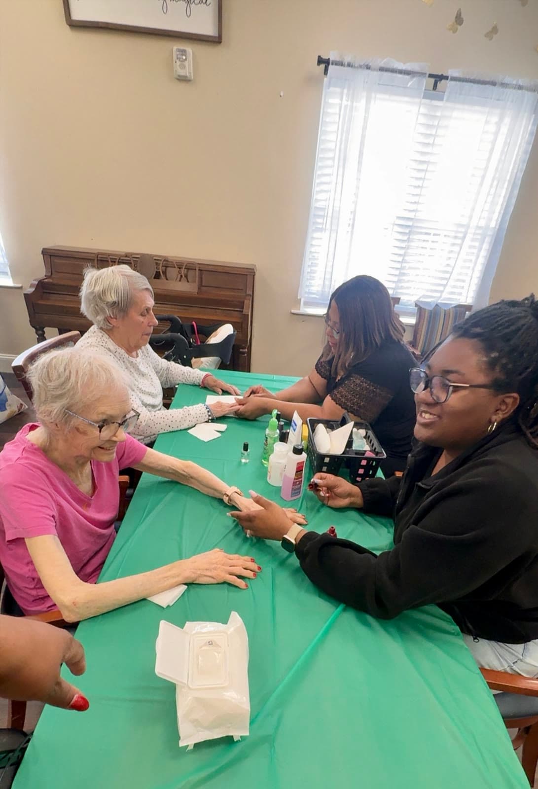 Seniors and volunteers gathered around the table during a Nail Ministry visit