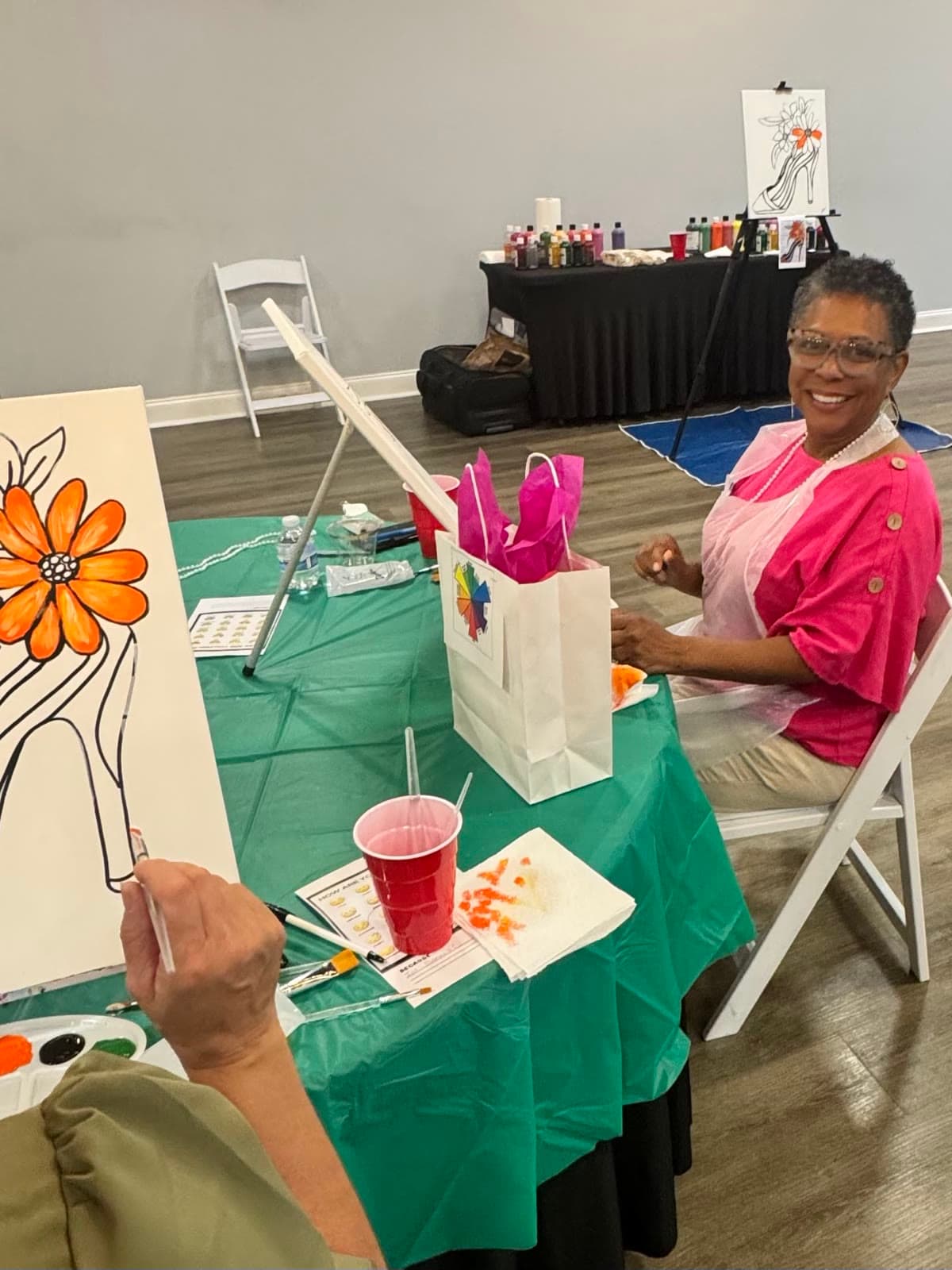 LIPSC member smiling at her easel during a paint event